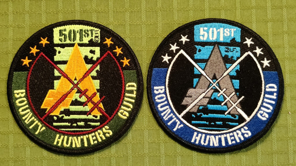 Two round embroidered patches. Only the colors are different. One is green and yellow (like Boba Fett), the other is blue and silver (like Jango Fett). The motive is the Bounty Hunters Guild logo, with a blaster crosshair aiming at an aurebesh symbol for credits. The background is the famous killstripes from Boba Fett's helmet. There's six stars, symbolizing the six original bounty hunters from Empire Strikes Back.