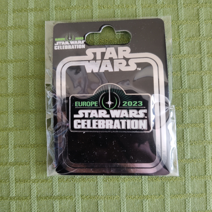 A pin still sealed in the bag. It is the Star Wars Celebration Europe 2023 logo.