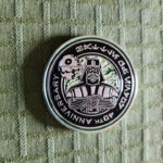 A coin with black, silver and forrest green details. Text: "40th Anniversary". Darth Vader is standing with his arms crossed. We also see the second Death Star in the background.