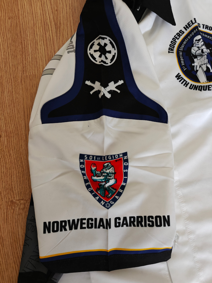 A close-up of the right sleeve of the white club shirt. We see that the epaulette in and the Norwegian Garrison logo better detail.