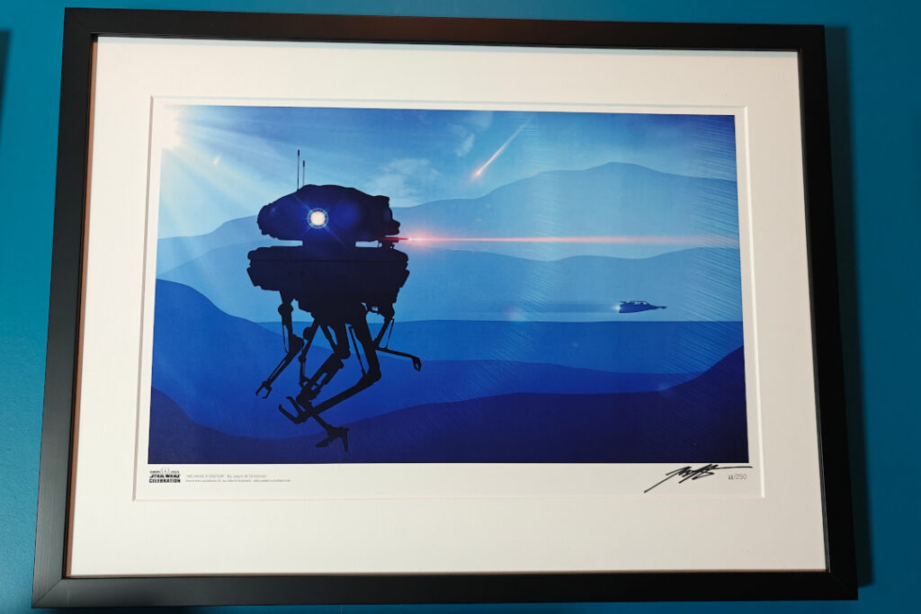 A framed artwork on a blue wall. We see a winter landscape with mountains in the background. A rebel snowspeeder is rushing by. An imperial probe droid is shooting at something out of frame. Many shades of blue.