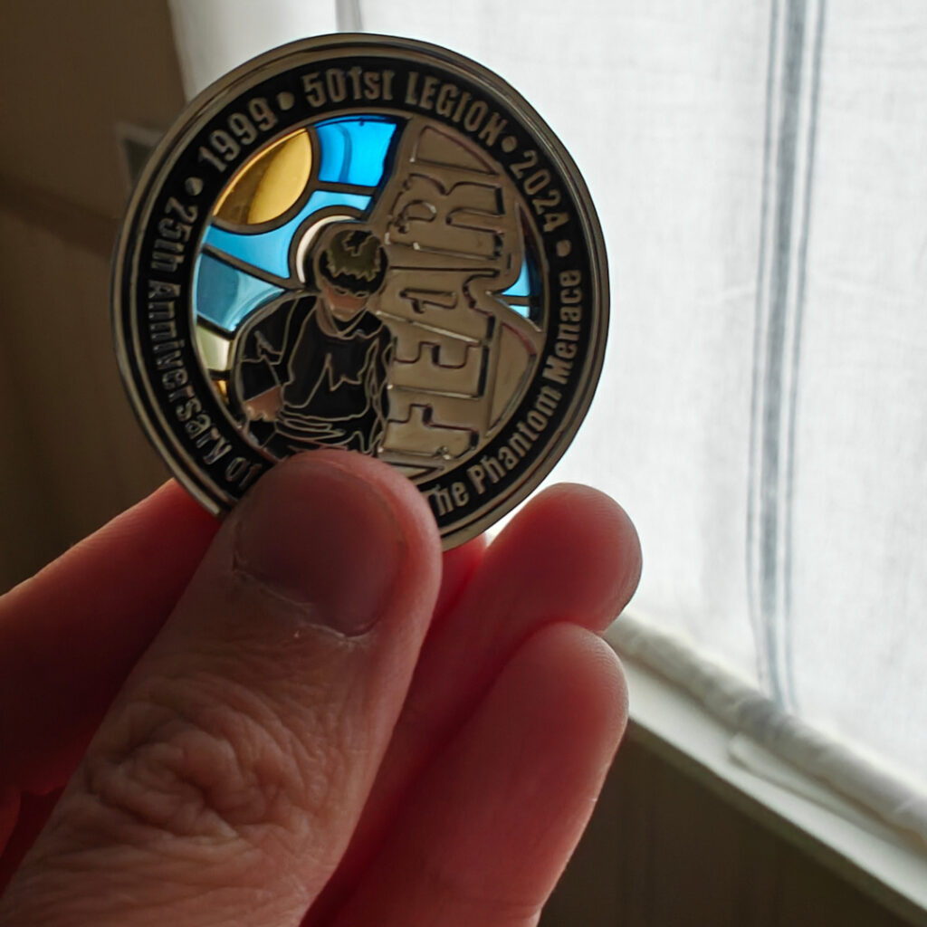 I am holding the coin up to the light. We see that the background is made of translucent glass.