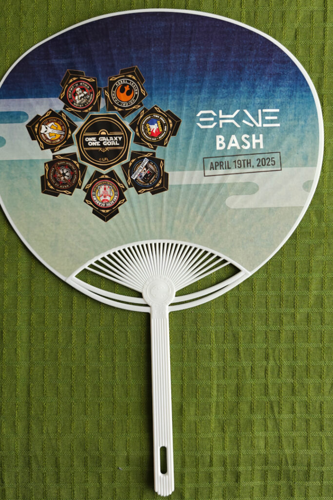 The back of the fan. To the left: The logos of the seven participating organizations in a ring, with "One galaxy, one goal" in the middle. To the right: "Bash, April 19th, 2025". The word "bash" is also written in aurebesh script.