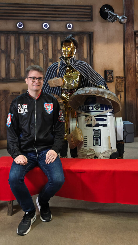 I am sitting on a bench. Behind me are two familiar droids, but dressed as rural japanese farmers.